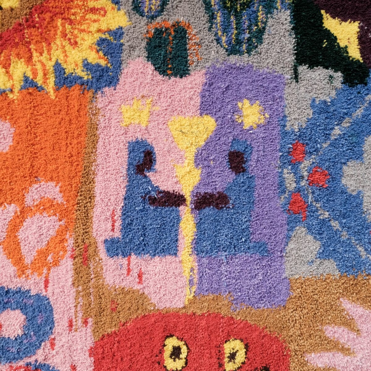 Färgglada tuftade figurer och blommor i närbild från Tufting Ex Machina.